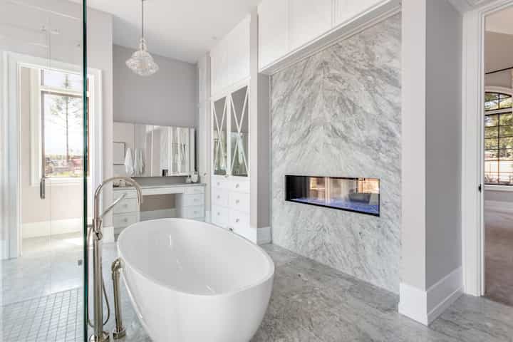 A gorgeous white marble bathroom remodeling with custom fireplace in Sun City Center, Florida mansion